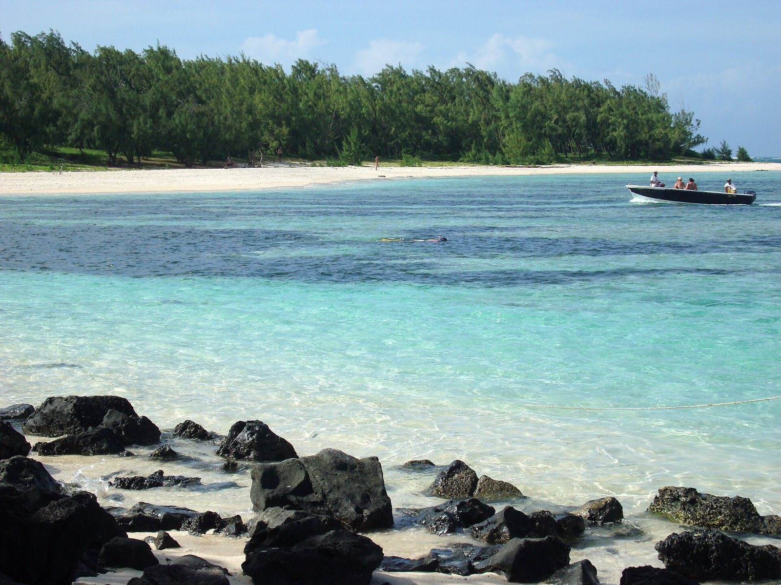 Türkisfarbene Lagune und dunkle Felsen vor der Île aux Cerfs
