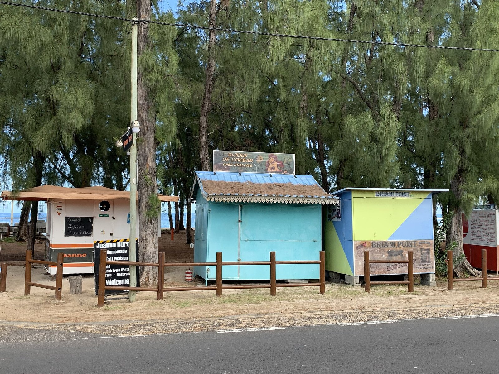 Bunte Imbissbuden unter Kasuarinen am Strand von Flic en Flac