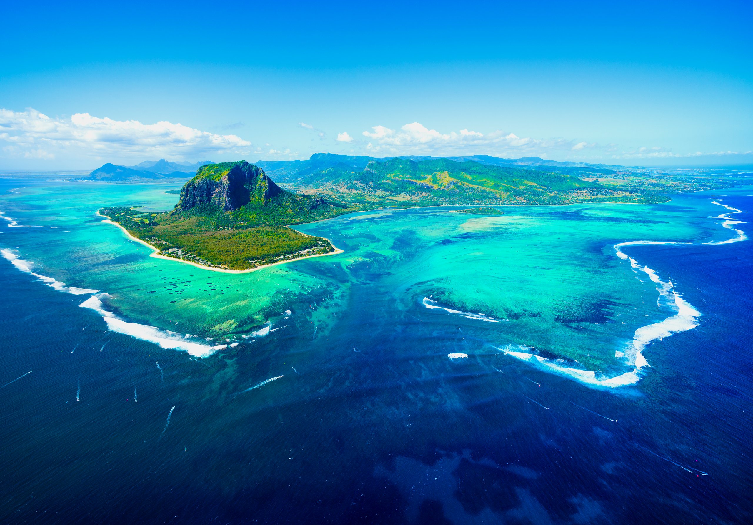 Die Halbinsel Le Morne aus der Luft, davor die türkise Lagune und der Unterwasser-Wasserfall am Riff
